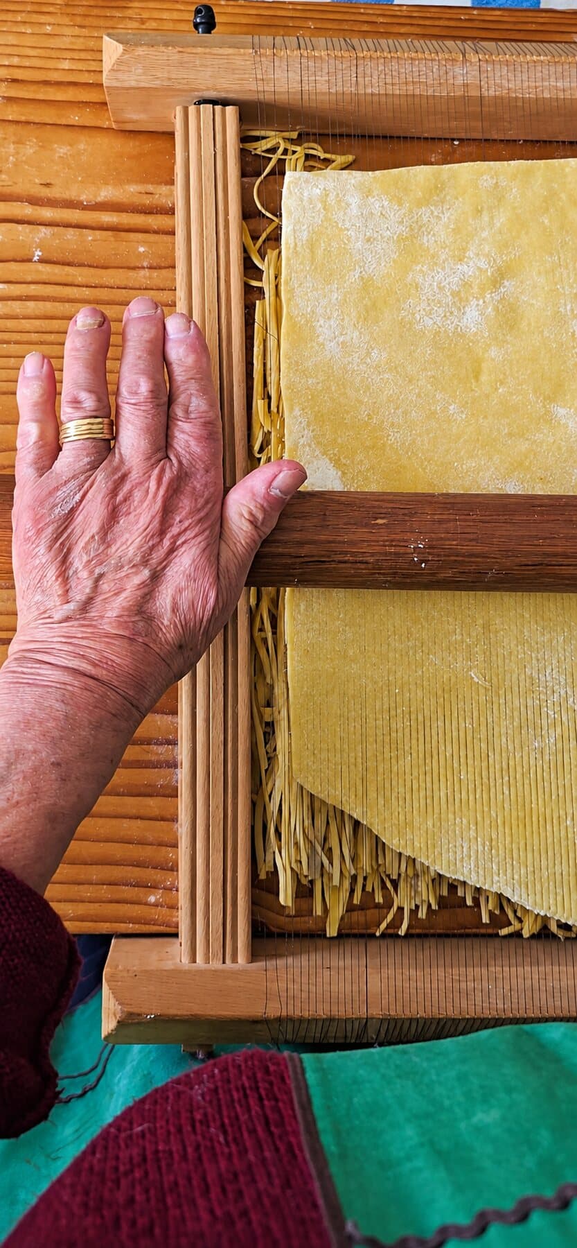 Une main ridée, l’alliance au doigt, posée sur la chitarra où la feuille de pasta devient spaghetti