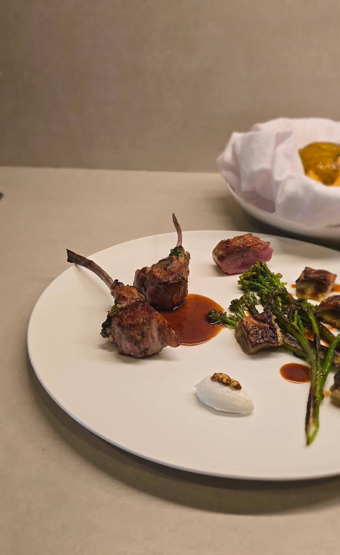 Côtelettes d’agneau rôties, jus et brocolis sur une assiette blanche