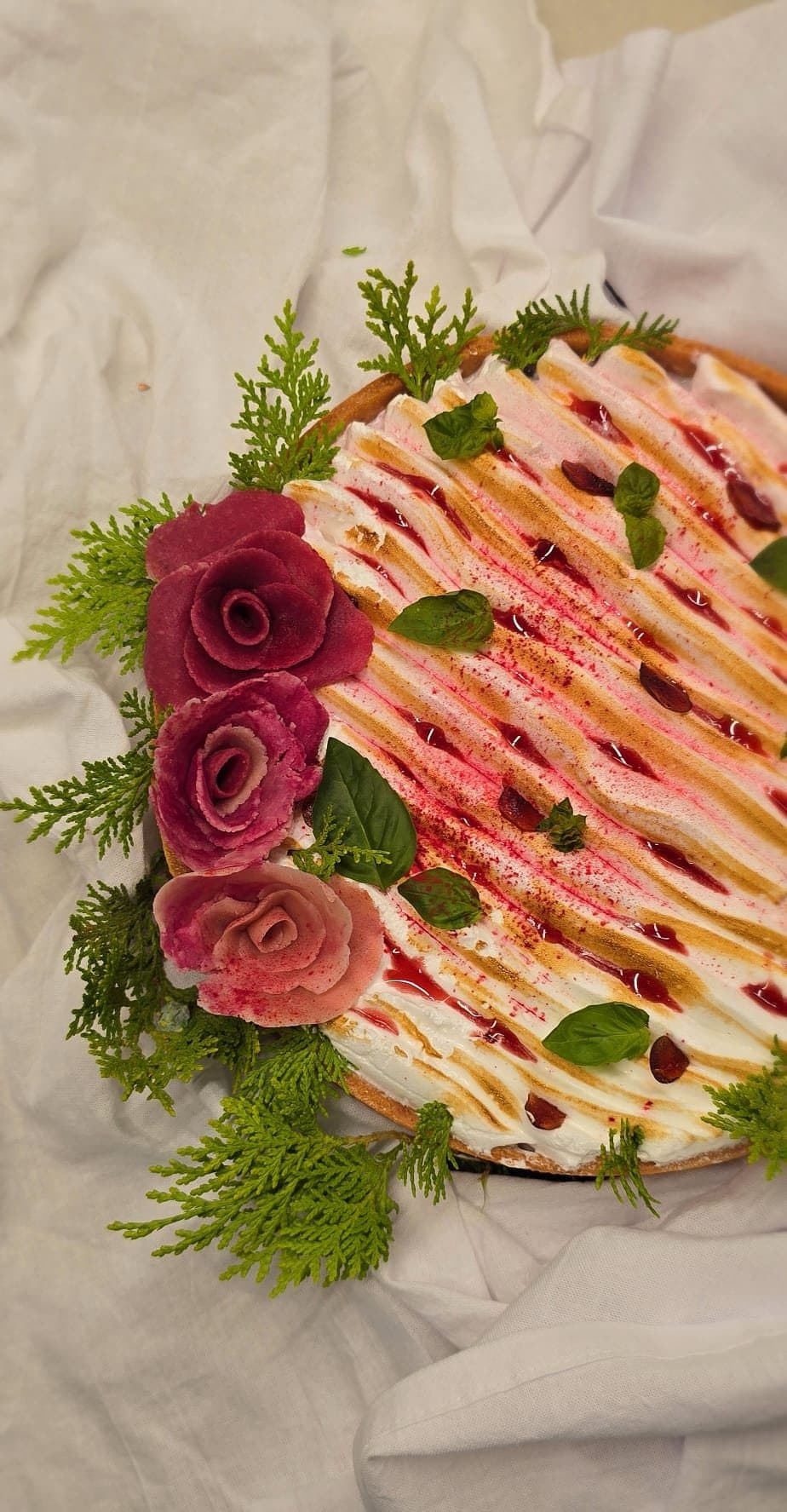 Un gâteau à la crème décoré de roses de betterave et de verdure