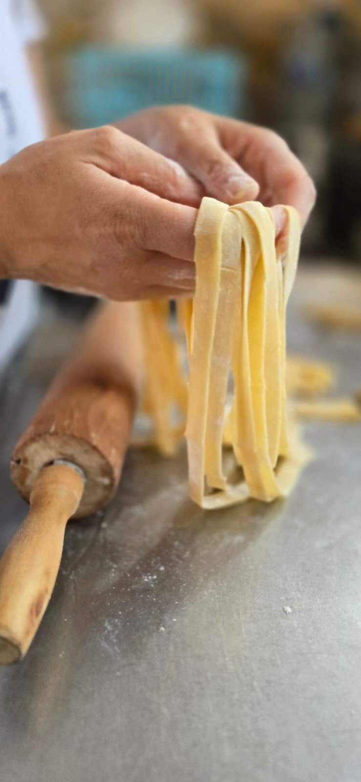 Des tagliatelle fraîches soulevées au-dessus du rouleau