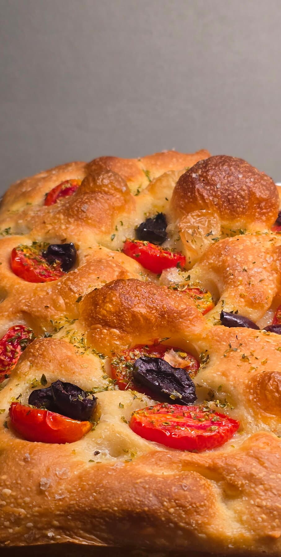 Une focaccia gonflée aux tomates cerises et aux olives noires